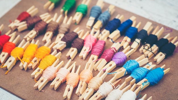 szpulki nici i igły obok haftu